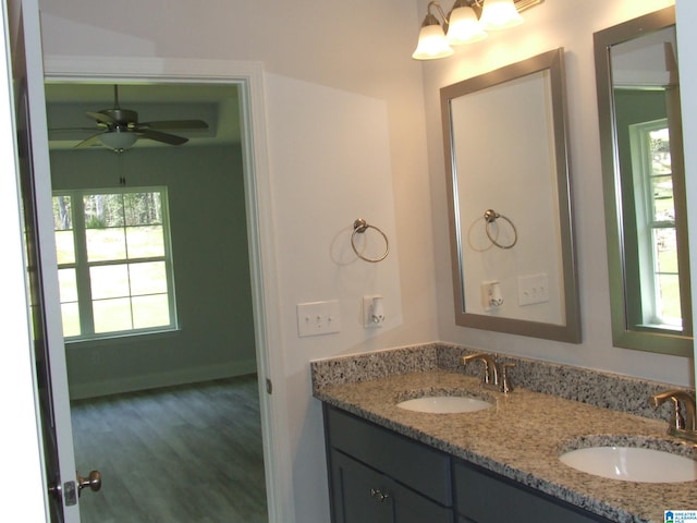 bathroom featuring double vanity, a ceiling fan, baseboards, and a sink