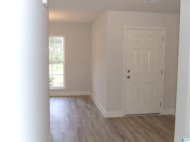 interior space with visible vents, baseboards, and wood finished floors