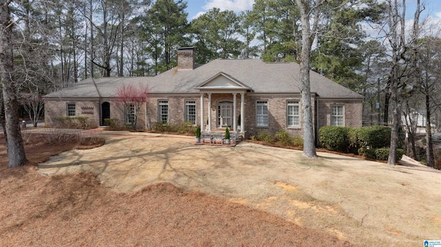 greek revival inspired property featuring brick siding and a chimney