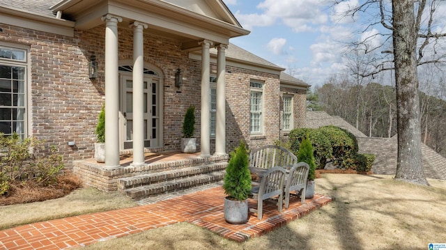 property entrance with brick siding and a shingled roof