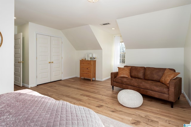 bedroom featuring lofted ceiling, baseboards, visible vents, and light wood finished floors