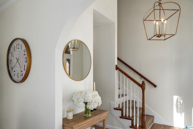 stairs featuring baseboards and an inviting chandelier