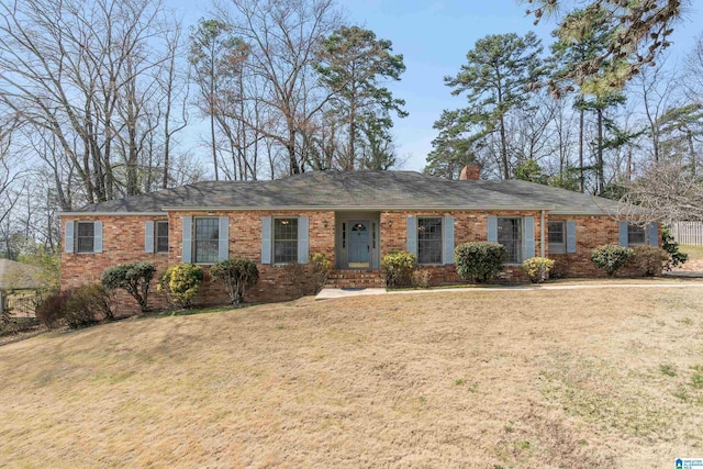 ranch-style house with brick siding, a chimney, and a front lawn