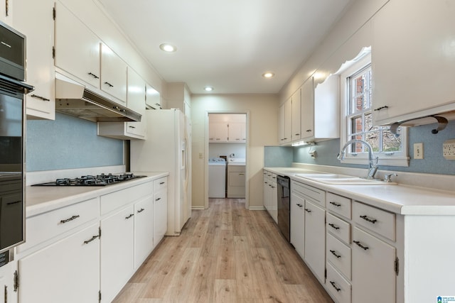 kitchen featuring a sink, black appliances, light countertops, white cabinetry, and separate washer and dryer