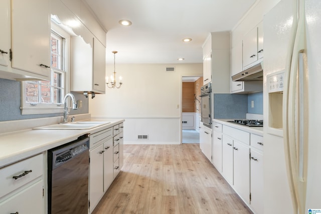 kitchen with oven, under cabinet range hood, black dishwasher, white refrigerator with ice dispenser, and a sink