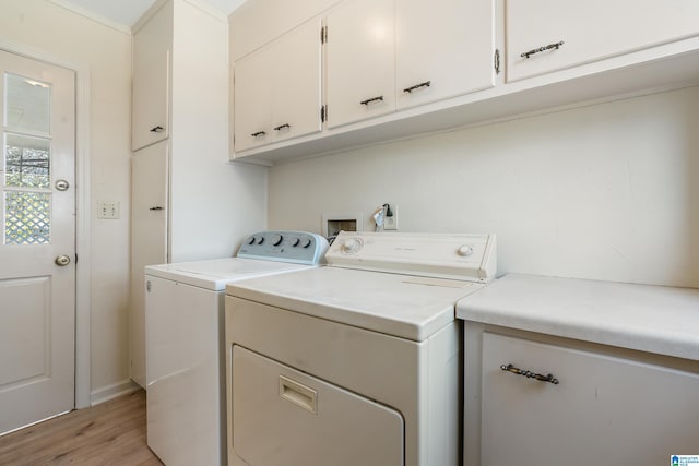 washroom with cabinet space, light wood-style floors, and washer and clothes dryer