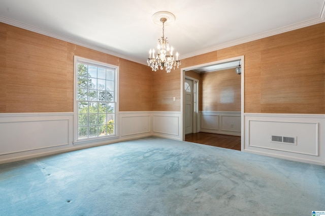 empty room with visible vents, a wainscoted wall, and carpet flooring