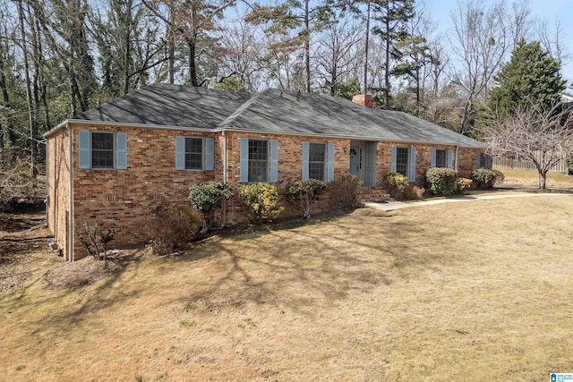 ranch-style house featuring a front lawn, brick siding, and a chimney