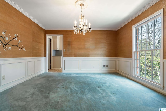 carpeted spare room featuring ornamental molding, visible vents, and wainscoting