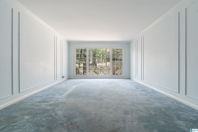 carpeted empty room with crown molding and a decorative wall