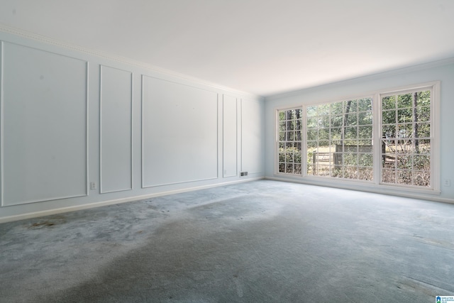 spare room with a decorative wall, carpet flooring, and ornamental molding