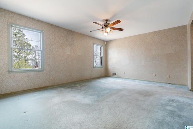 unfurnished room featuring a ceiling fan, visible vents, and carpet floors