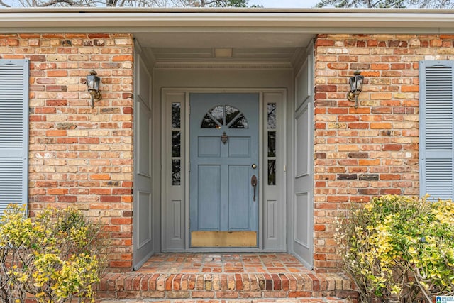 view of exterior entry with brick siding