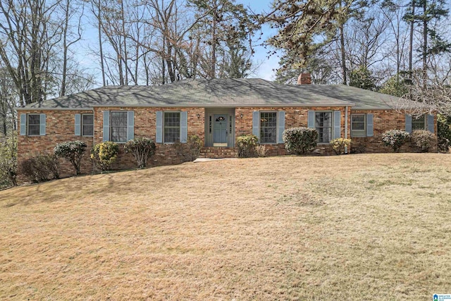 single story home with a front yard, brick siding, and a chimney