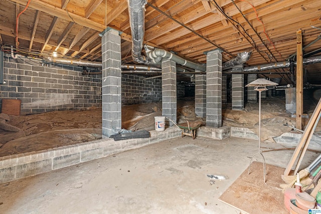 basement featuring crawl space, concrete block wall, and heating fuel