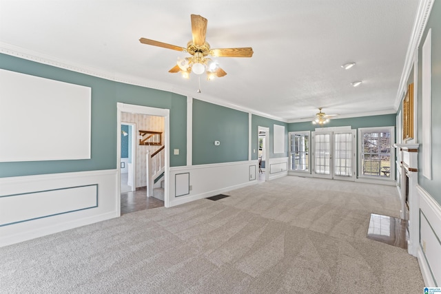 unfurnished living room with visible vents, carpet, stairs, crown molding, and a decorative wall