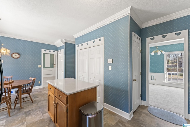 kitchen with a textured ceiling, a chandelier, wallpapered walls, brown cabinetry, and crown molding