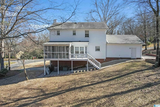 rear view of house with stairway, a chimney, cooling unit, and a sunroom