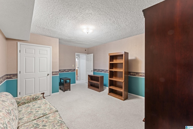 interior space featuring carpet, baseboards, and a textured ceiling