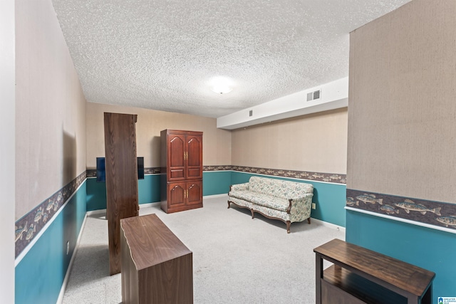 living area with carpet floors, baseboards, visible vents, and a textured ceiling