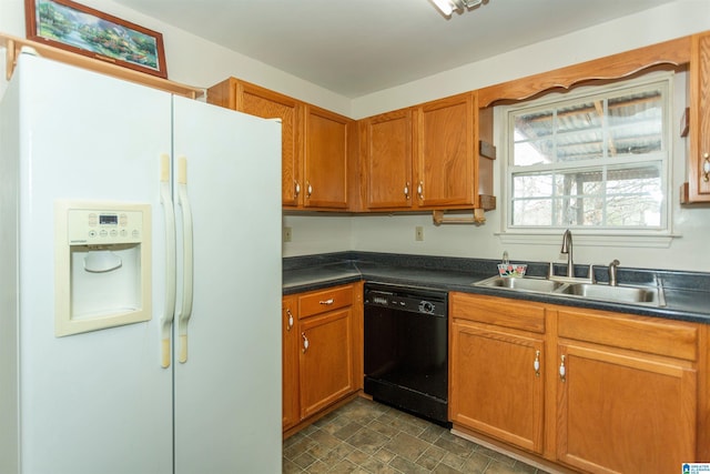 kitchen featuring white refrigerator with ice dispenser, brown cabinetry, dishwasher, dark countertops, and a sink