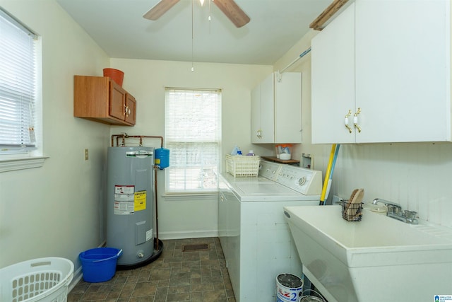 laundry area with a sink, water heater, independent washer and dryer, cabinet space, and stone finish flooring