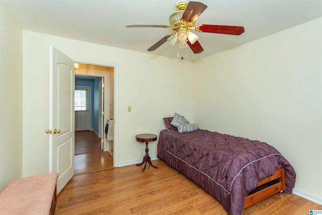 bedroom featuring ceiling fan, light wood-type flooring, and baseboards