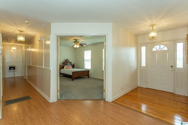 foyer featuring baseboards, visible vents, heating unit, and wood finished floors