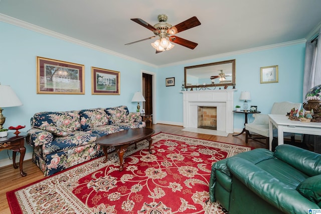 living area with wood finished floors, a ceiling fan, and ornamental molding