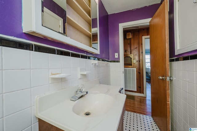 bathroom with visible vents, tile walls, a wainscoted wall, and vanity