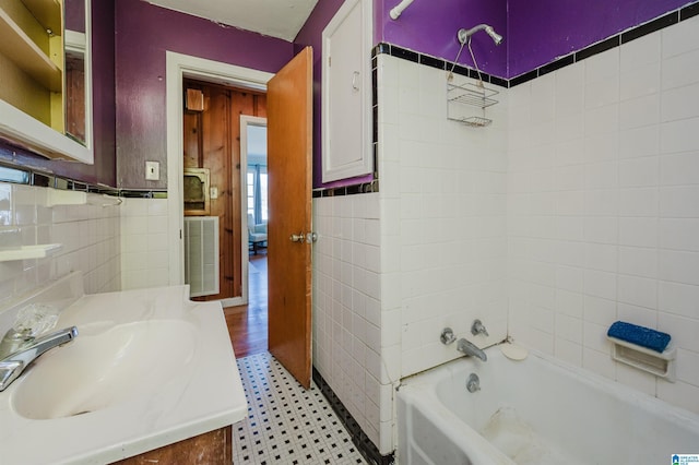 full bathroom featuring visible vents, shower / tub combination, tile walls, and vanity