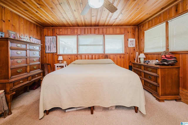 bedroom with ceiling fan, light colored carpet, wooden ceiling, and wooden walls