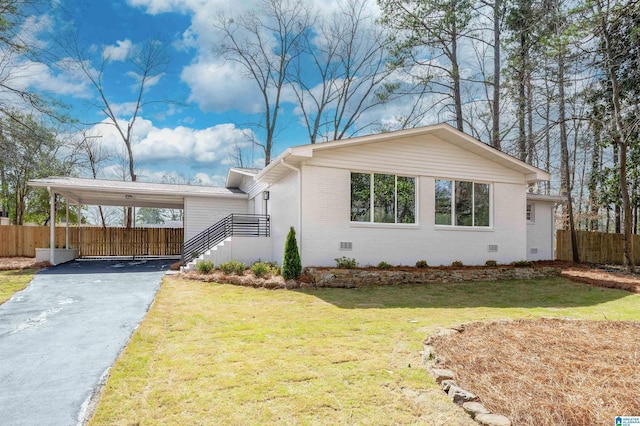 view of front of property featuring a front lawn, driveway, fence, crawl space, and brick siding