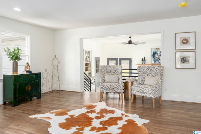 living area featuring an upstairs landing, recessed lighting, baseboards, and wood finished floors