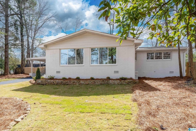 view of front of property with crawl space, brick siding, and a carport