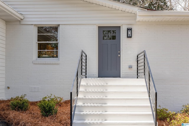 doorway to property with brick siding