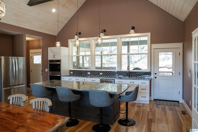 kitchen featuring light wood finished floors, decorative backsplash, and appliances with stainless steel finishes