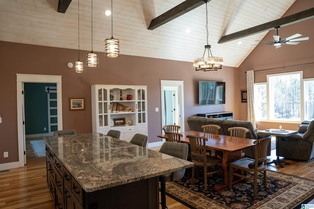 dining space with beam ceiling, high vaulted ceiling, wood finished floors, baseboards, and ceiling fan