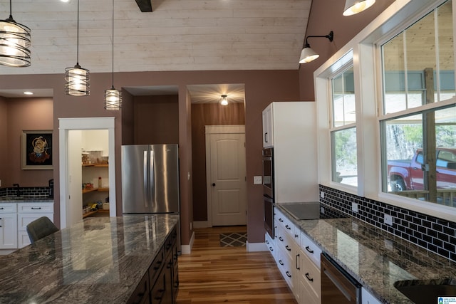 kitchen with decorative backsplash, white cabinets, appliances with stainless steel finishes, and pendant lighting