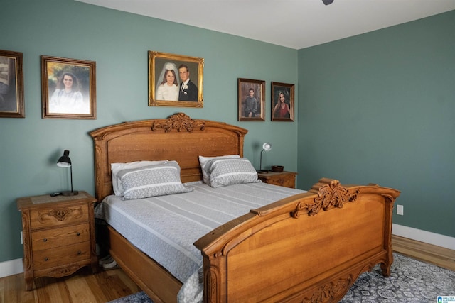 bedroom with baseboards and wood finished floors