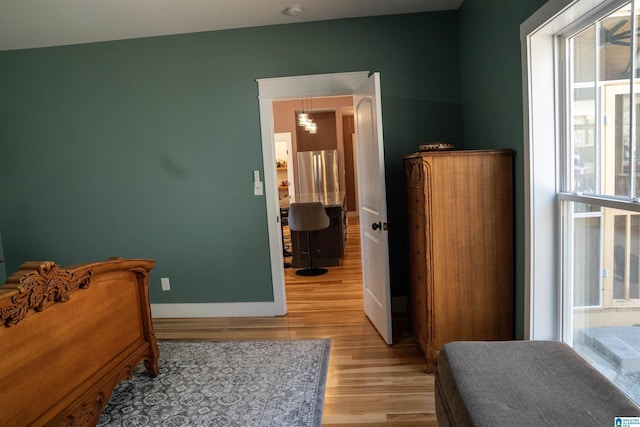 bedroom featuring baseboards and light wood finished floors