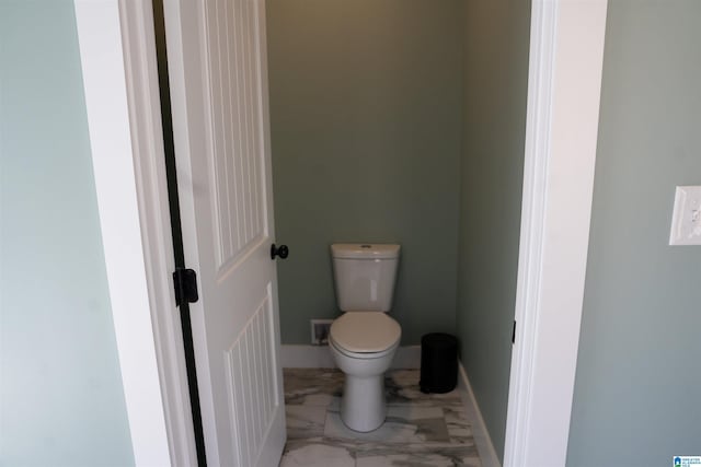 bathroom with toilet, baseboards, and marble finish floor