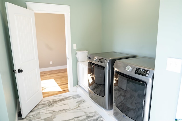 laundry room with laundry area, baseboards, marble finish floor, and washer and clothes dryer