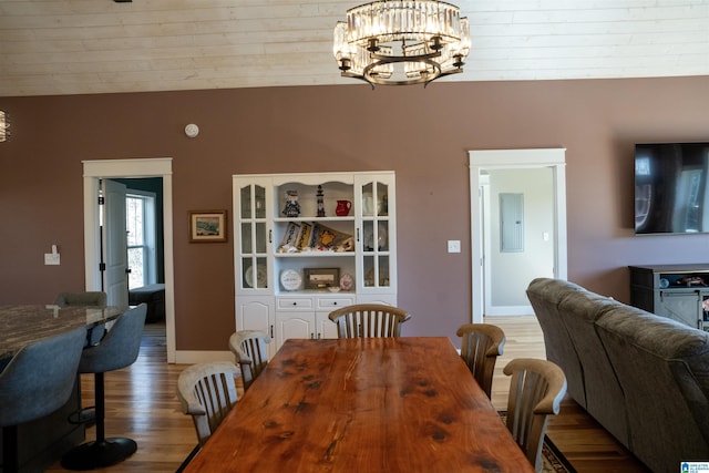 dining area with baseboards, a notable chandelier, and wood finished floors