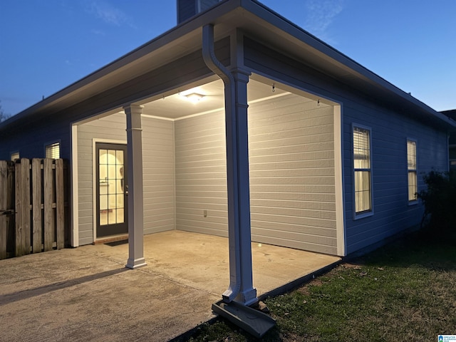 view of property exterior with fence and a patio