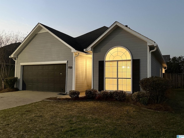 ranch-style home featuring a front lawn, concrete driveway, and an attached garage