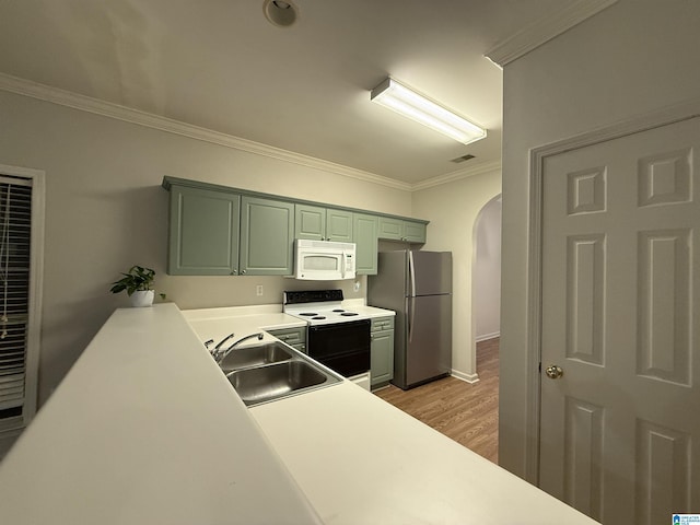 kitchen featuring arched walkways, crown molding, light wood finished floors, a sink, and white appliances