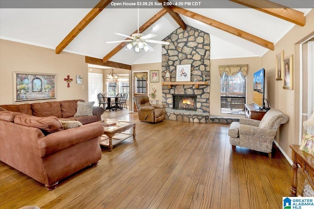 living room with a healthy amount of sunlight, hardwood / wood-style flooring, a fireplace, and beamed ceiling