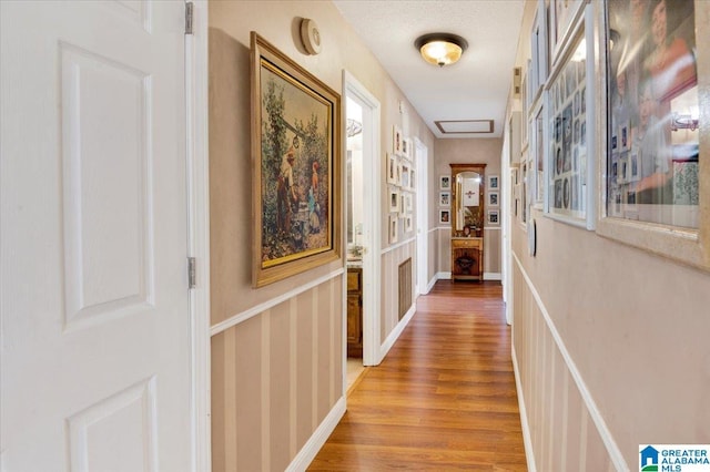 corridor with light wood-style floors and baseboards