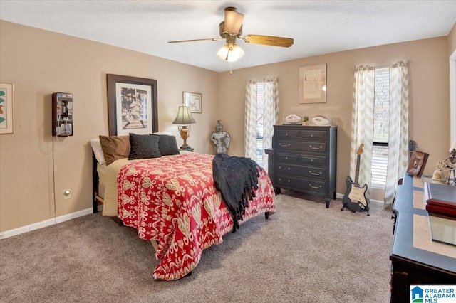 carpeted bedroom with ceiling fan, a textured ceiling, and baseboards